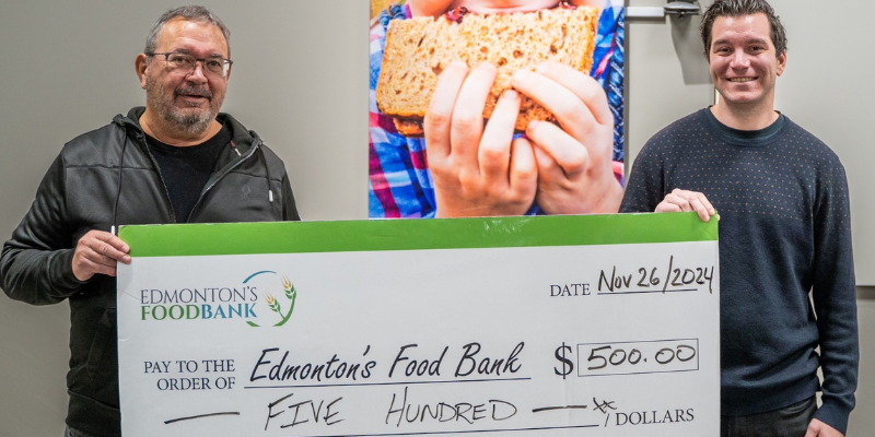 UNB Alumni Chapters give back, picture of a donation cheque being handed to a charity representative