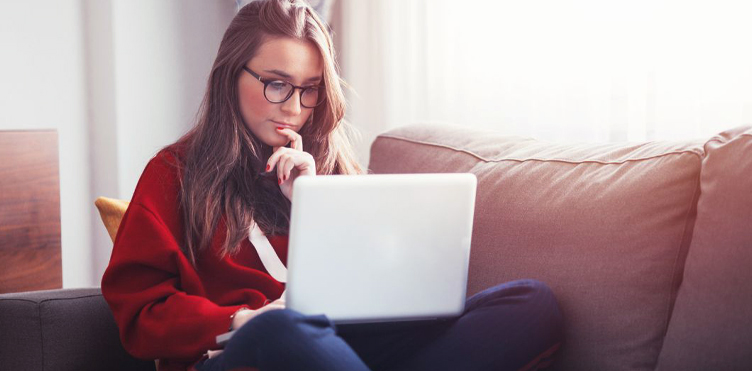 Photograph of a woman sitting with her laptop